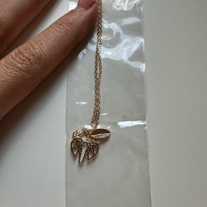 an gold elephant necklace with a leaf charm